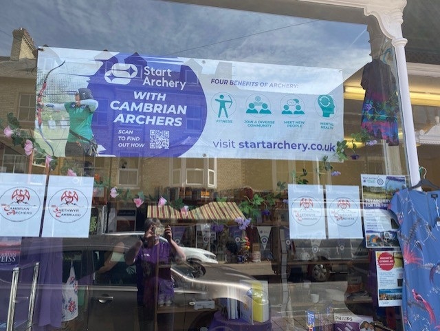 Charity shop window with club poster