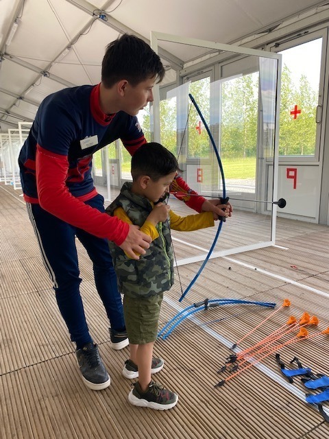 Max helping a boy to shoot