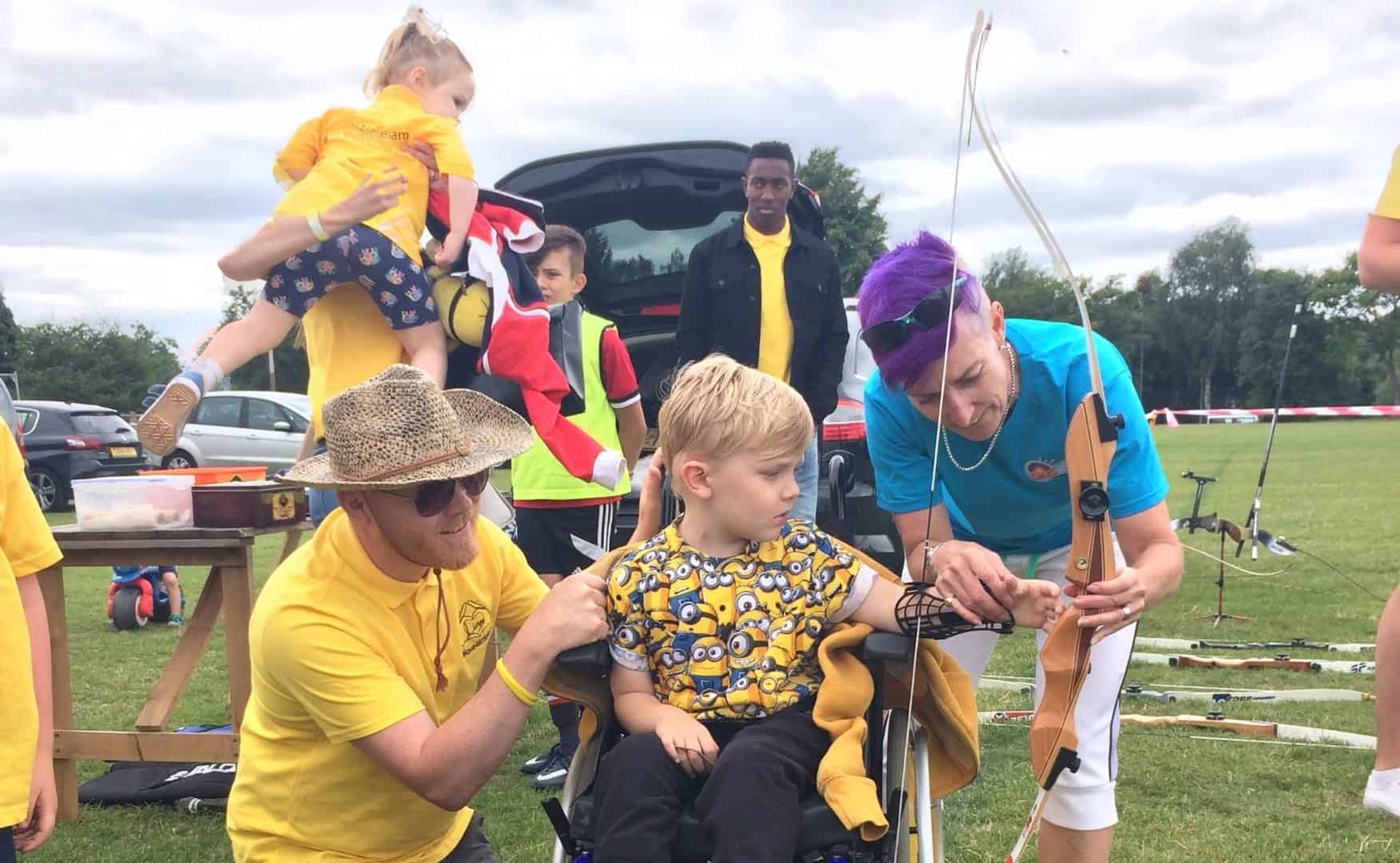 Archery coaches helping a child to try archery at a Big Weekend event