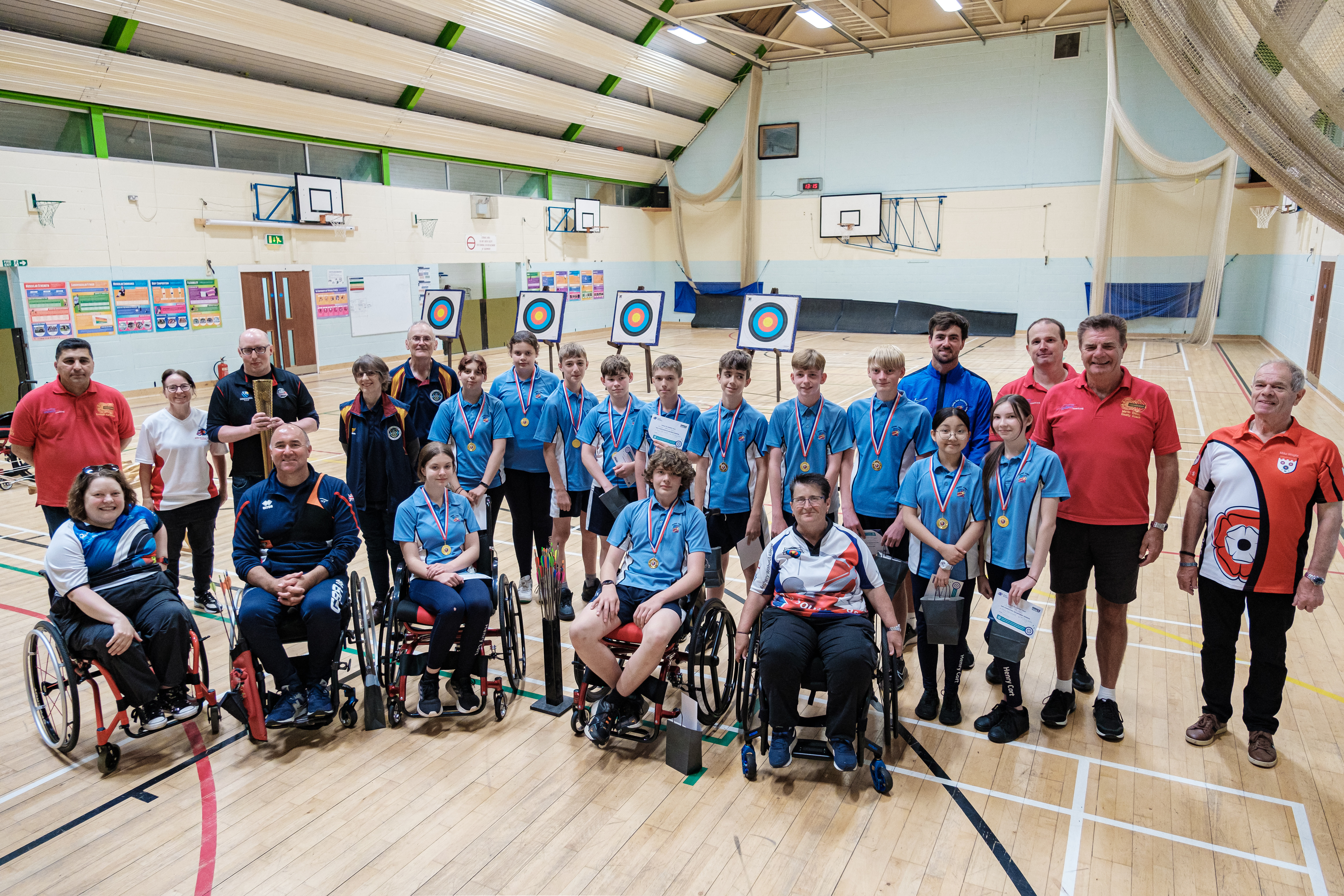 Archers and students smiling in front of targets